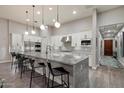 Bright, modern kitchen with white cabinets, stainless steel appliances, and a large gray granite island with bar stool seating at 7340 E Conquistadores Dr, Scottsdale, AZ 85255