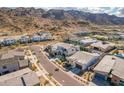 An aerial shot of a desert community shows modern homes with mountain views in background at 921 E Buist Ave, Phoenix, AZ 85042