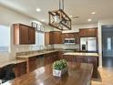 Spacious kitchen features stainless steel appliances, wood cabinets, granite countertops, and a large kitchen island at 10909 E Sentiero Ave, Mesa, AZ 85212