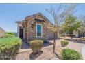 Charming single-story home featuring stone accents, manicured landscaping, and a paved driveway leading to a garage at 12035 W Roy Rogers Rd, Peoria, AZ 85383