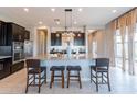 Beautiful kitchen with granite countertops, black cabinets, modern appliances, and a spacious center island with seating at 12035 W Roy Rogers Rd, Peoria, AZ 85383