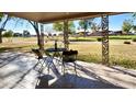 Cozy covered patio with decorative supports and tile flooring overlooks the beautiful golf course at 18442 N 104Th Ave, Sun City, AZ 85373