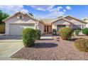 Charming single-story home with a well-maintained front yard and two-car garage, showcasing great curb appeal at 20218 N 61St Ave, Glendale, AZ 85308