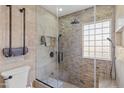 Spa-like bathroom featuring glass-enclosed shower with stone tile and modern fixtures at 2366 E Shea Blvd, Phoenix, AZ 85028