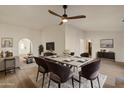Dining room with seating for six, modern chandelier, and light hardwood floors at 2366 E Shea Blvd, Phoenix, AZ 85028