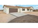 View of the home's garage and new concrete driveway at 24938 S 190Th Dr, Buckeye, AZ 85326