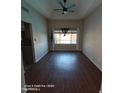 Bright living room featuring wood floors, a ceiling fan and a window with backyard views at 2825 N Villas N Ln, Chandler, AZ 85224