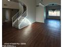 Spacious living room featuring wood floors, a staircase, and an archway to the backyard at 2825 N Villas N Ln, Chandler, AZ 85224