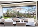Elegant dining area with desert views and stylish light fixture next to a covered patio with seating at 3045 W Feather Sound Dr, Anthem, AZ 85086