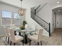 Formal dining room with glass top table, six chairs, and modern chandelier lighting at 3875 E Appaloosa Rd, Gilbert, AZ 85296