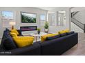 Bright living room with modern fireplace, large screen TV, and gray sofa with yellow pillows at 3875 E Appaloosa Rd, Gilbert, AZ 85296