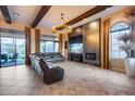 Spacious living room featuring beamed ceilings, a modern fireplace and tile flooring at 42001 N Bridlewood Way, Phoenix, AZ 85086