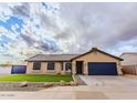 Single-story home with manicured lawn, blue garage door, gravel landscaping, and ample parking space at 502 N 110Th St, Mesa, AZ 85207