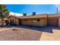 Single-story home with desert landscaping, featuring a driveway and brick facade under a clear blue sky at 8519 E Rancho Vista Dr, Scottsdale, AZ 85251