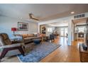 A spacious living room with hardwood floors, a ceiling fan, and an open floor plan into the dining and kitchen areas at 8519 E Rancho Vista Dr, Scottsdale, AZ 85251