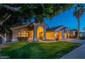 Beautiful single-story home featuring lush green lawn, mature trees, and a covered front entry at 10431 N 55Th Pl, Paradise Valley, AZ 85253