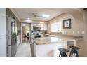 Bright kitchen with white cabinetry, stainless steel appliances, a skylight, and a breakfast bar at 1246 E Acoma Dr, Phoenix, AZ 85022