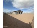 View of the spacious backyard with cinder block fence and desert landscaping at 15773 W Hackamore Dr, Surprise, AZ 85387