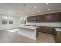 Bright, open kitchen boasts a large white island, modern appliances, and sleek wood-toned cabinetry at 17793 W Southgate Ave, Goodyear, AZ 85338