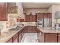 Gourmet kitchen featuring granite countertops, stainless steel appliances, and custom cabinetry at 30056 N 129Th Ave, Peoria, AZ 85383