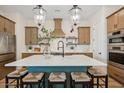 Stunning kitchen featuring a large island with seating, pendant lighting, stainless steel appliances, and custom cabinets at 550 E Aurora Dr, San Tan Valley, AZ 85140