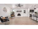 Open-concept living area boasts natural light, a painted brick fireplace, and seamlessly connects to the kitchen at 709 N San Jose N Cir, Mesa, AZ 85201