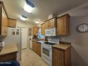 Bright kitchen boasts white appliances, wooden cabinets, and ample counter space at 8700 E University Dr # 615, Mesa, AZ 85207