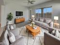 Cozy living room featuring plush seating, stylish rug, and abundant natural light from the large windows at 12164 S 184Th Ave, Goodyear, AZ 85338