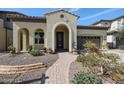 Inviting single-story home with a neutral stucco facade, arched entryway, and well-manicured landscaping at 122 N Bay Dr, Gilbert, AZ 85233