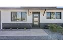 Contemporary front door with black trim and accents and desert landscaping with gravel and native plants at 1238 N 78Th St, Scottsdale, AZ 85257