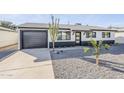 Charming home featuring a low maintenance gravel yard, black and white exterior paint, and desert landscaping at 1238 N 78Th St, Scottsdale, AZ 85257