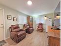 Warm living room featuring hardwood floors, leather seating, and bright natural light from the windows at 124 S 54Th St # 42, Mesa, AZ 85206