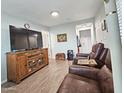 Comfortable living room with a large TV, wood-style floors, and a cozy leather reclining sofa at 124 S 54Th St # 42, Mesa, AZ 85206