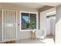 Covered entryway features a security door, window, and charming white wicker chair at 20218 N 33Rd Pl, Phoenix, AZ 85050