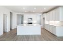 Spacious kitchen boasts a center island, recessed lighting, and stylish wood-look floors at 25606 N 154Th Ln, Surprise, AZ 85387
