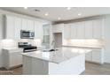 Bright kitchen features a large island, stainless steel appliances, and white cabinets at 25606 N 154Th Ln, Surprise, AZ 85387