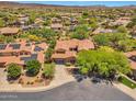 Expansive aerial view of a residential neighborhood featuring homes with tile roofs, solar panels, and mature trees at 30227 N 124Th Dr, Peoria, AZ 85383