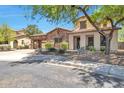 Beautiful desert home with stone accents, covered entryway, and mature landscaping creating a serene curb appeal at 30227 N 124Th Dr, Peoria, AZ 85383