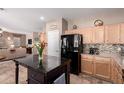 Cozy kitchen with ample storage and prep space, featuring a black refrigerator and modern finishes at 32795 N Hidden Canyon Dr, San Tan Valley, AZ 85144
