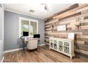 Cozy home office with wood accent wall, modern desk setup, and ample natural light at 4845 E Iolite St, San Tan Valley, AZ 85143