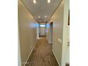 Hallway featuring neutral carpet, archways, and a view of the front door and transom window at 4943 W Lynne Ln, Laveen, AZ 85339