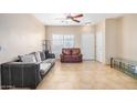 Open living room with tile floors, ceiling fan, and natural light from the front window at 525 N Miller Rd # 113, Scottsdale, AZ 85257