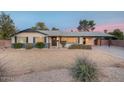 Lovely single-story home showcasing desert landscaping and a convenient covered carport at 6845 E Lewis Ave, Scottsdale, AZ 85257