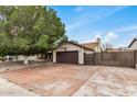 Charming home featuring a spacious driveway, large tree, and fenced entrance at 8201 W Tuckey Ln, Glendale, AZ 85303