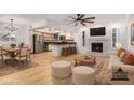Bright, open-concept living room featuring hardwood floors, fireplace, and kitchen island with bar seating at 8201 W Tuckey Ln, Glendale, AZ 85303