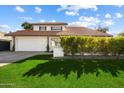 Charming two-story home featuring lush front lawn, tile roof, and a two-car garage at 8607 N Farview Dr, Scottsdale, AZ 85258