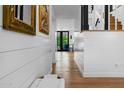 Inviting hallway showcasing hardwood floors, shiplap walls, and decorative mirrors, leading to rear door at 8607 N Farview Dr, Scottsdale, AZ 85258