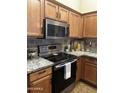 Bright kitchen showcasing stainless steel appliances, granite countertops, and warm wooden cabinets at 16336 N 168Th Ave, Surprise, AZ 85388