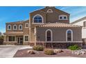 Charming two-story home featuring desert landscaping, arched windows, and a tile roof at 21216 N 96Th Ave, Peoria, AZ 85382