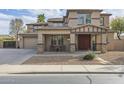 Charming front of two-story home with covered porch and a three car garage at 21503 E Alyssa Ct, Queen Creek, AZ 85142